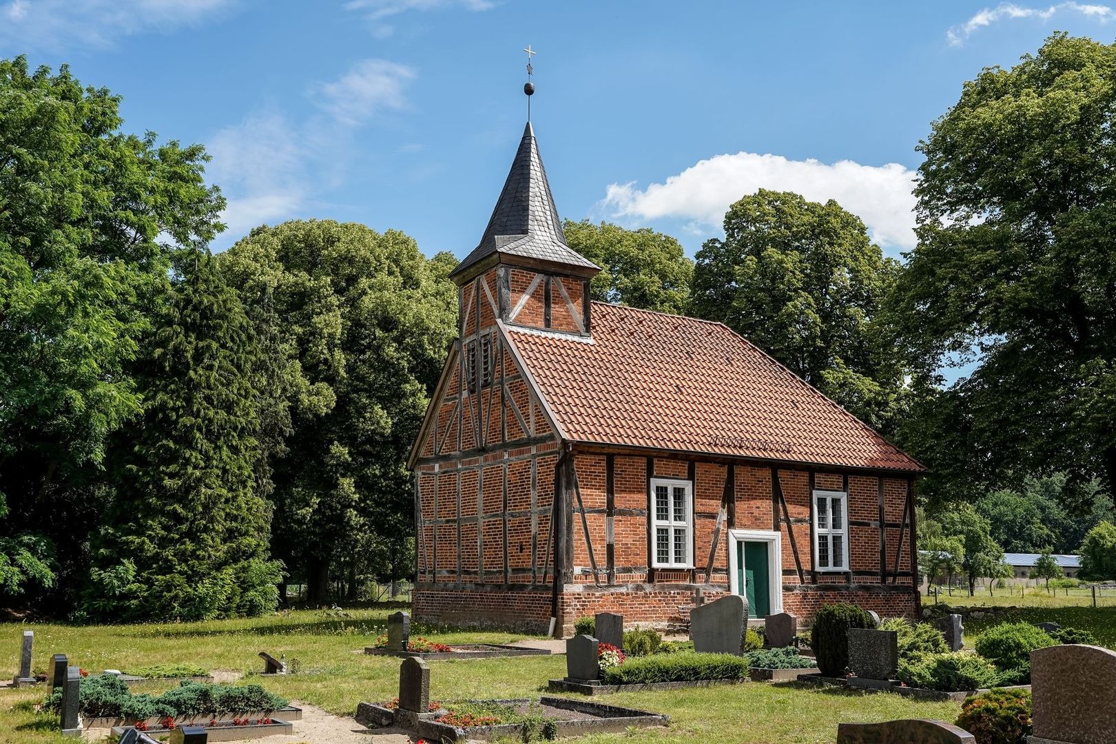 Historische Backsteinkirche mit Oktogon-Turm auf einem Friedhof in Ludorf